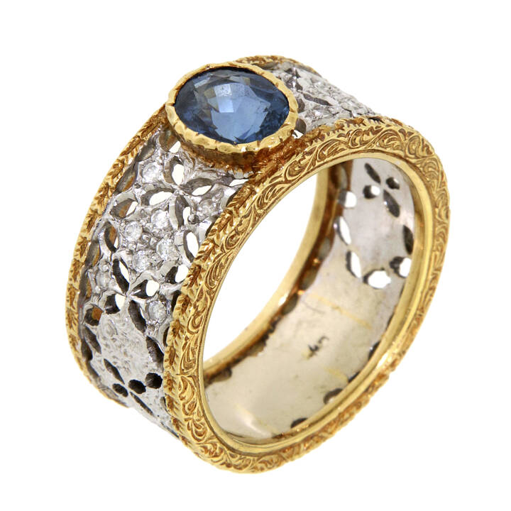 ANELLO - Anello in oro giallo e bianco, lavorato a pizzo con piccoli diamanti taglio brillante per complessivi ct 0,20 ca, al centro zaffiro taglio ovale<br>Peso g 10,9 <br>Misura 20