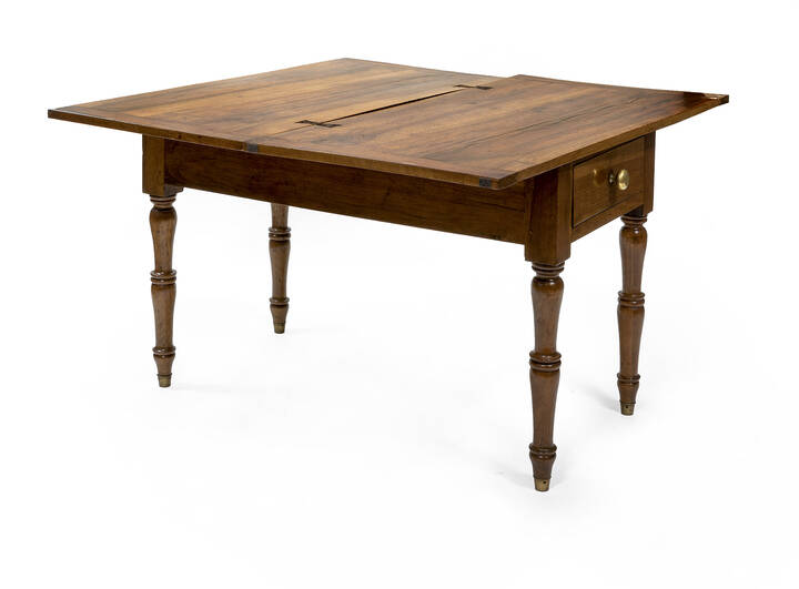 TAVOLO - Tavolo a libro in noce bionda, epoca XIX secolo, un cassetto; gambe lavorate terminanti con zoccolo in metallo