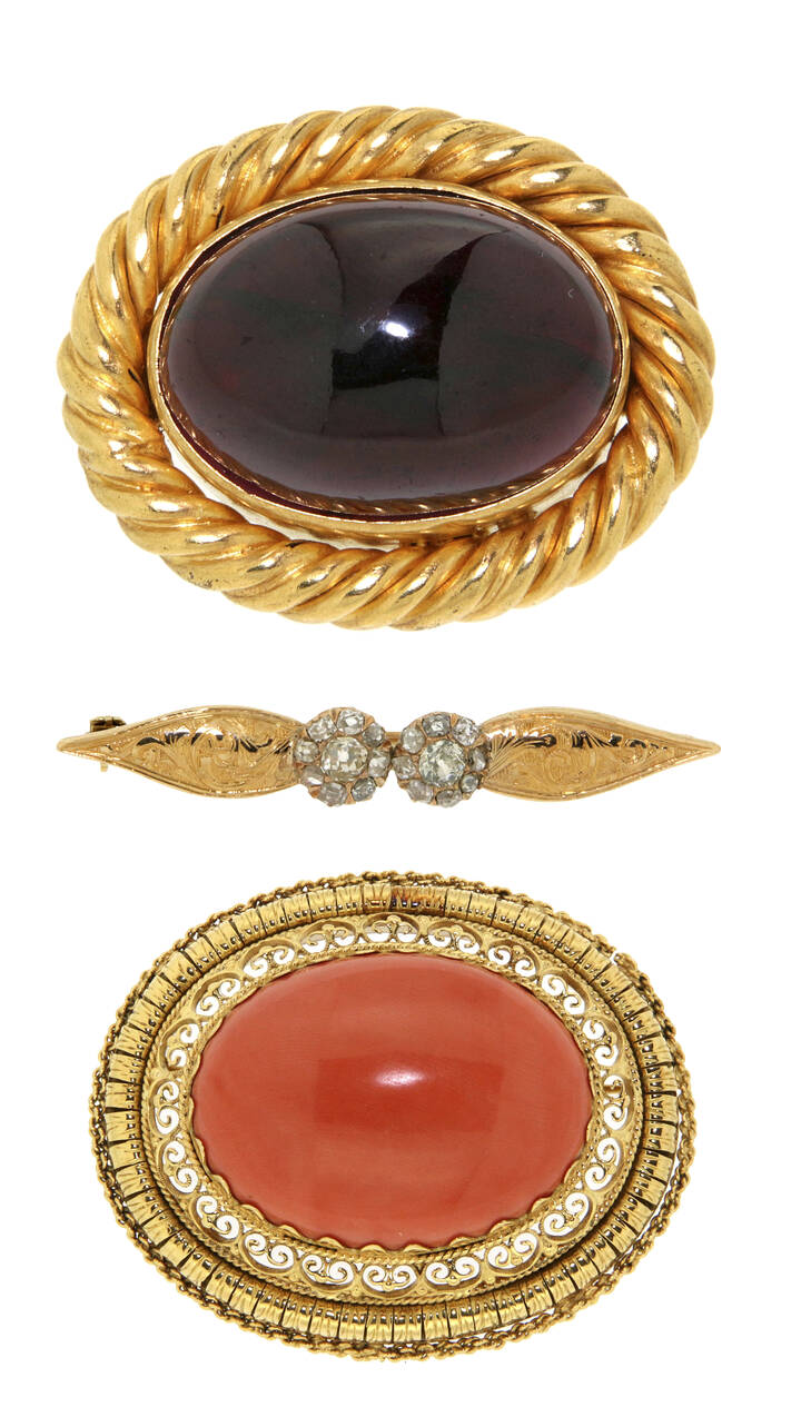 LOTTO DI TRE SPILLE - Lotto composto da tre spille in oro giallo: la prima di forma ovale, lavorata a pizzo, con al centro corallo orientale taglio cabochon; la seconda di forma ovale lavorata a torciglione con al centro granato cabochon; la terza, a forma di barretta con diamanti taglio brillante di vecchio taglio <br>Peso gr 41,5