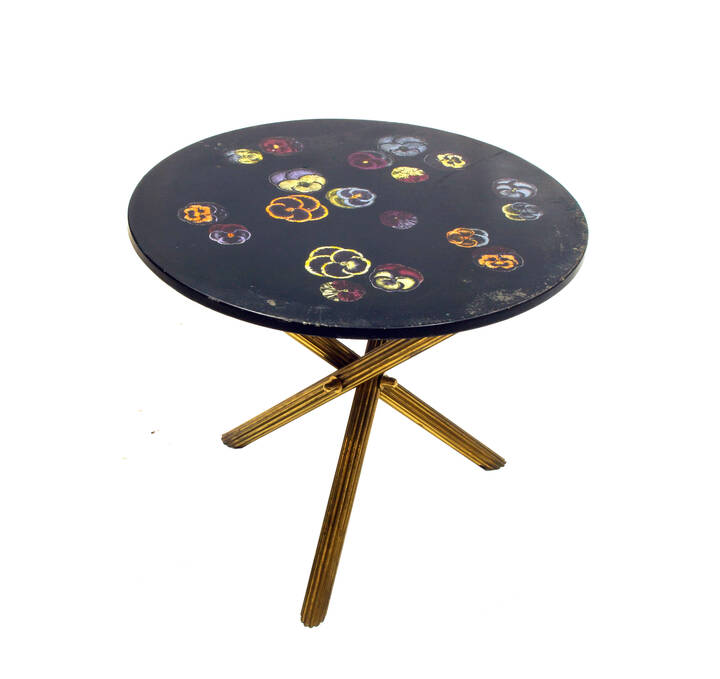 PIERO FORNASETTI - Tavolino con piano in legno laccato e decorato a serigrafia, supporto in ottone.